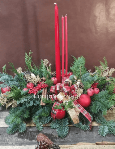 Centrotavola natalizio rosso, con candel, bacche e abete.
